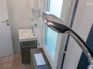 a bathroom with a sink and a toilet and a window at Portofelice Camping Village in Eraclea Mare