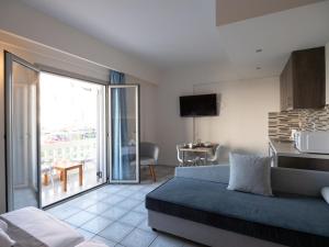 a room with a bed and a kitchen with a balcony at Aristo Apts in Hersonissos