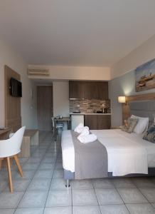a hotel room with two beds and a kitchen at Aristo Apts in Hersonissos