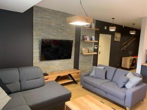 uma sala de estar com dois sofás e uma televisão em Apartamenty Stara Polana em Zakopane