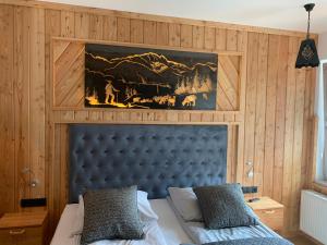 una camera da letto con un letto con testiera blu di Apartamenty Stara Polana a Zakopane Altre 87 foto
