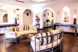 a lobby with couches and a table and mirrors at Hotel O'scià in Lampedusa