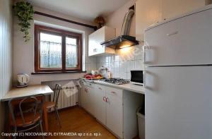 a kitchen with a white refrigerator and a table at ,,u Uli'' kwatery i domek in Piwniczna-Zdrój