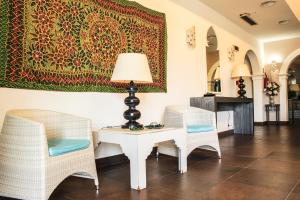 a room with two chairs and a table with a lamp at Hotel O'scià in Lampedusa