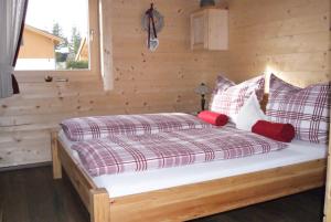 ein Schlafzimmer mit einem Bett mit einer Holzwand in der Unterkunft Chalet Bergheimat in Wagrain