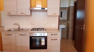 a kitchen with a stove and a sink at Residence Il Vicoletto in Brolo +20 photos
