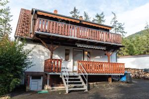 a house with a deck and a staircase in front of it at Ferienwohnung im Ottenhai (EG) in Bad Harzburg