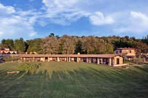 una casa grande en un campo con un gran patio en Villa Hotel Valle Del Marta Resort, en Tarquinia