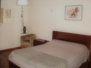 a small bedroom with a bed and a table at Casa do Linhar - Quintas de Sirlyn in Tondela