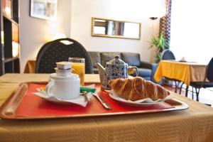 einen Tisch mit einem Teller Brot und einer Tasse Kaffee in der Unterkunft Hotel Hippodrome in Paris