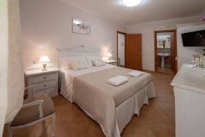 1 dormitorio con cama blanca y lavamanos en Vico d'Ercole en Fondi