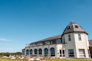 a large white building with a gambrel roof at Lanhydrock Hotel & Golf Club in Bodmin