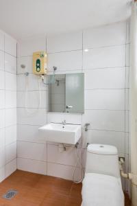 Baño blanco con lavabo y espejo en Subang Park Hotel, en Subang Jaya