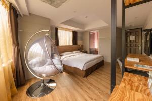 una camera da letto con un letto, una sedia e una scrivania di RF Hotel - Zhongxiao a Taipei