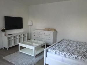 a white bedroom with a bed and a tv at Penzion U Zamku in Jaroměřice na Rokytné