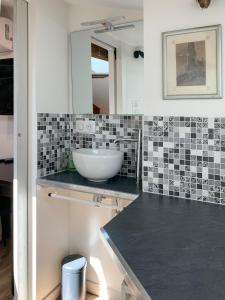 La salle de bains est pourvue d'un lavabo et d'un miroir. dans l'établissement Les Appartements du Palais, à Bergerac