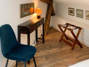 um quarto com uma secretária, uma cadeira e um candeeiro em Les Appartements du Palais em Bergerac