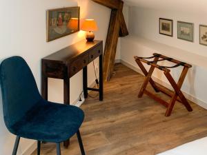 Cette chambre comprend un bureau, une chaise et une lampe. dans l'établissement Les Appartements du Palais, à Bergerac