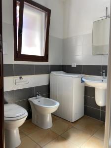 ein Bad mit einem WC und einem Waschbecken in der Unterkunft Le Villette di Budoni e dintorni in Budoni