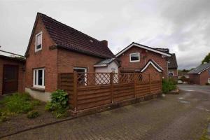 a house with a wooden fence in front of it at Süßes Apartmenthäuschen in Burg in Burg