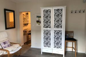 a white cabinet in a living room with a couch at Süßes Apartmenthäuschen in Burg in Burg +3 photos