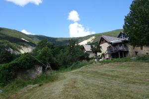 a house on the side of a hill with a dirt road at Gite d'Aliège in Péone