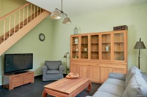 a living room with a couch and a tv at De Statie in Brecht