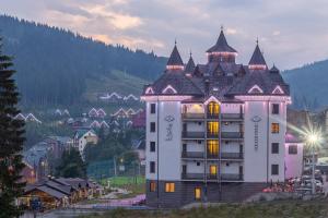 um grande edifício branco com uma torre em Mardan Palace SPA Resort em Bukovel