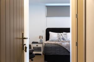 カティカティにあるTalisman Hotel & Restaurantのベッドルーム1室(ベッド1台、ランプ付きテーブル付)