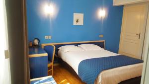 Habitación azul con cama y pared azul en Modern'Hotel, en Valenciennes