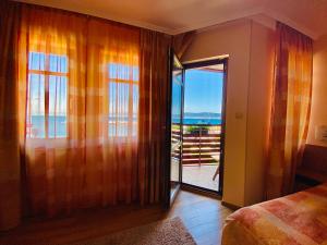 Schlafzimmer mit Glasschiebetür zum Balkon in der Unterkunft Family Hotel Saint Nikola in Nessebar