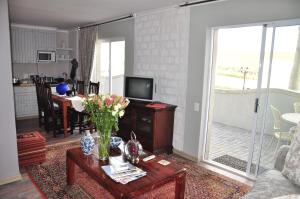 una sala de estar con una mesa con flores. en Dieu Donne en Stellenbosch