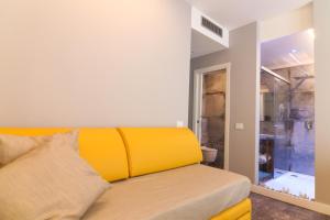 un divano giallo in camera con bagno di J Luxury Home a Tropea