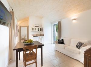 Una sala de estar con un sofá blanco y una mesa. en Masseria Il Mandorlo Fiorito x 8 Piscina Privata, en Ceglie Messapica