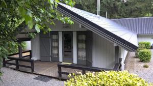 uma casa com um deque de madeira e um alpendre em Chalet Joran & Naomi em Barvaux