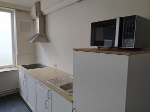 uma cozinha com um micro-ondas e um lavatório em Casa Lommel em Lommel