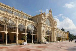 ein großes Gebäude mit Leuten, die davor laufen in der Unterkunft Villa Shafaly in Marienbad