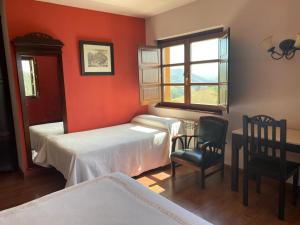 - une chambre avec 2 lits, un bureau et une fenêtre dans l'établissement Hotel Rural Yeguada Albeitar, à Villayón