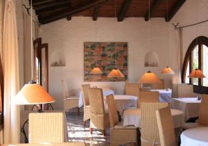 a restaurant with white tables and chairs and lamps at Hotel Villa Mediterranea in Noto Marina