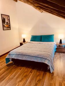 1 dormitorio con 1 cama con almohadas azules y 2 lámparas en Bellisimo chalet en Zona Colonial (302), en Zipaquirá