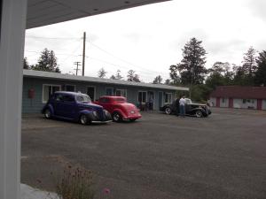 dos coches viejos estacionados frente a un edificio en Ocean Avenue Inn, en Westport