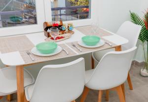a white dining room table with white chairs and a table and chairsktop at Rilassunte Luxury apartments in Potos