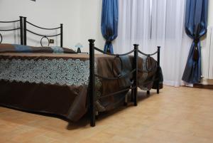 2 camas en una habitación con cortinas azules en Palazzo Bonfranceschi, en Belforte del Chienti