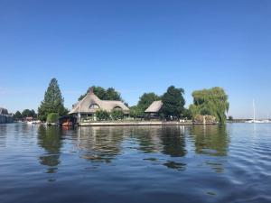 a house on a island in the middle of a lake at Beach House Giethoorn in Wanneperveen +13 photos