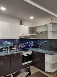a kitchen with white cabinets and a sink at White Apartment in Kazanlŭk