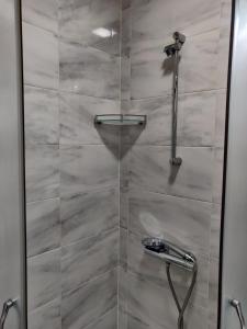 a shower with a glass door in a bathroom at White Apartment in Kazanlŭk