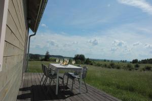 - une table et des chaises sur une terrasse couverte offrant une vue sur un champ dans l'établissement Mazury Garbate - Dom I przy Cisowym Jarze, à Kowale Oleckie