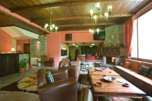 a living room with a wooden table and leather chairs at Archontiko Velousi in Pantévgeni +63 photos