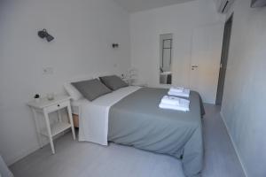 a white bedroom with a large bed and a table at Lagos Central Apartments Ap 9 in Lagos