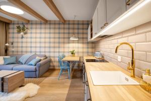 a kitchen and living room with a couch and a table at VRÁTNA Apartmány Stoh B1 in Terchová